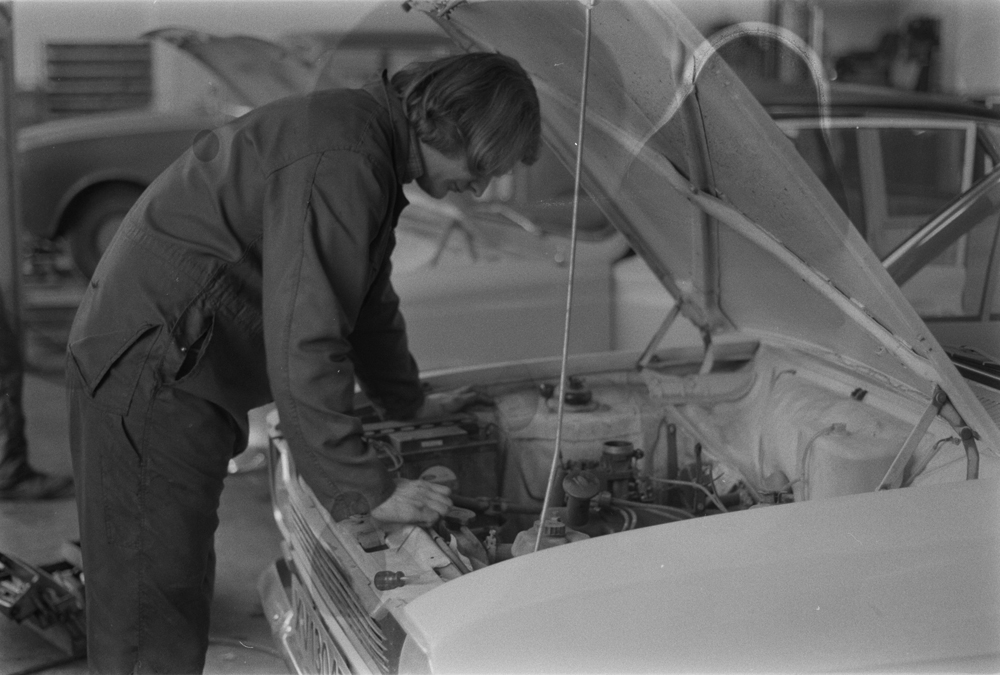 Lind & Greva i Mosjøen, Mars 1975. Markering i forbindelse med 20 år som Ford forhandler.
Bilmekaniker Knut Eirik Tverå bøyd over motorrom.