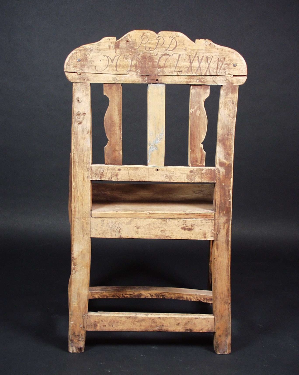 Stolen er av bjørk og har utskjæringer med akantus og rocailler på stolryggen og på framre sarg. Stolen har antagelig vært rødmalt.