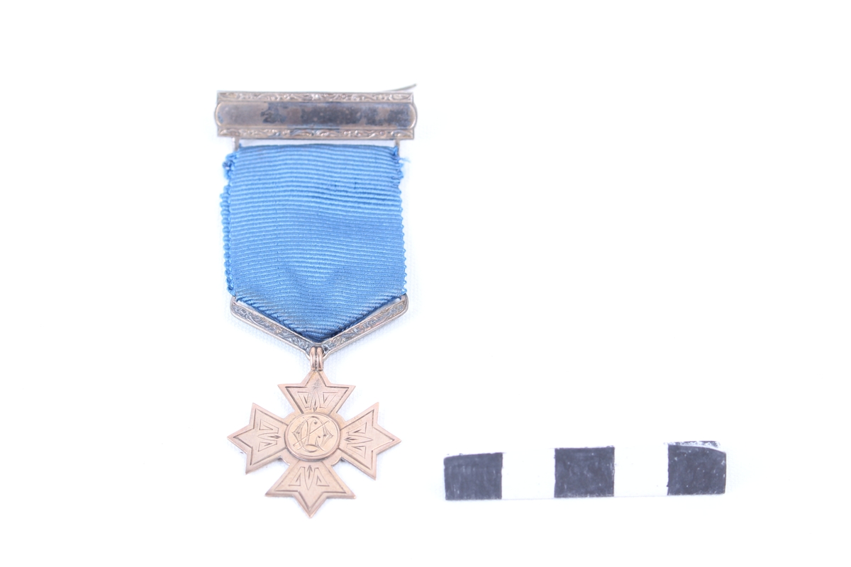 Stjerneformet medalje med blått medaljebånd og agraff.
