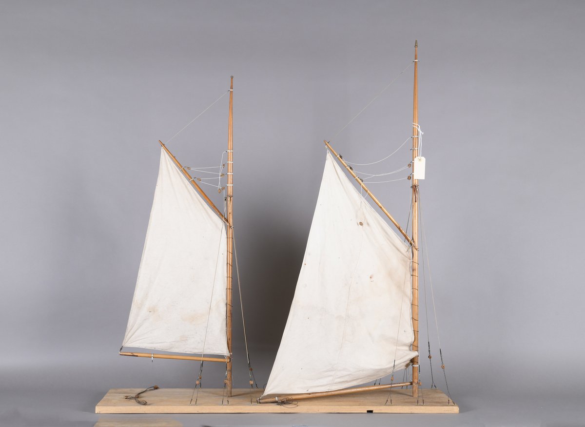 Båtmodell bestående av en flat plate med to master som begge har mesangaffel og mesanbom. Begge master har utslåtte mesanseil. Svært enkel modell med lite detaljer.