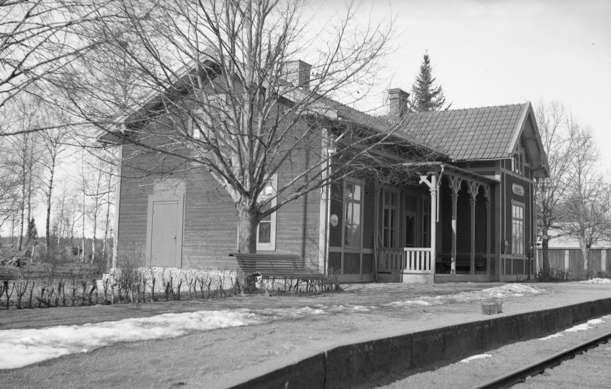 Trafikplats med envånings stationshus i trä, byggt i vinkel. Byggnaden renoverades 1946