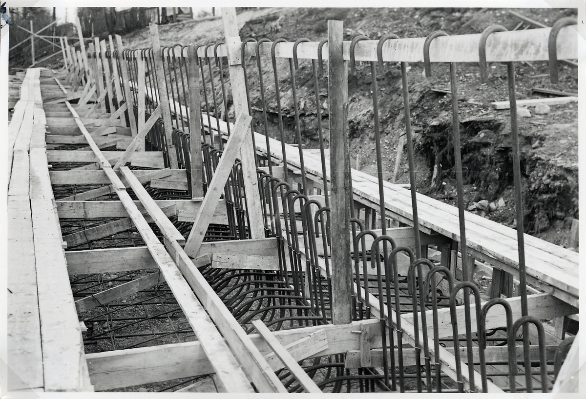 Uppförande av stödmur för järnvägsbanken vid byggnationen av ny järnvägsviadukt över Norrtullsgatan. Belägen ca 100 m öster om östra landfästet i nya vidaukten.
Grundplattan armerad.
