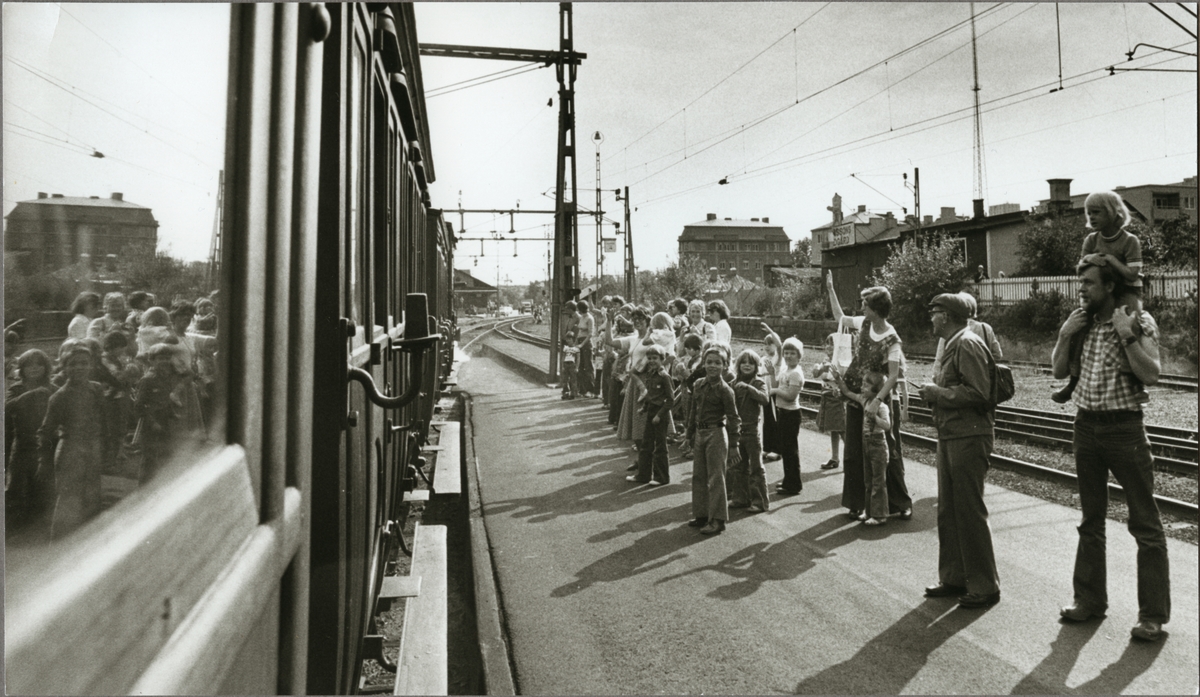 Folksamling på perrongen där ett persontåg av äldre typ står under jubileet av Oxelösund - Flen - Västmanlands Järnväg, OFWJ 100 år.