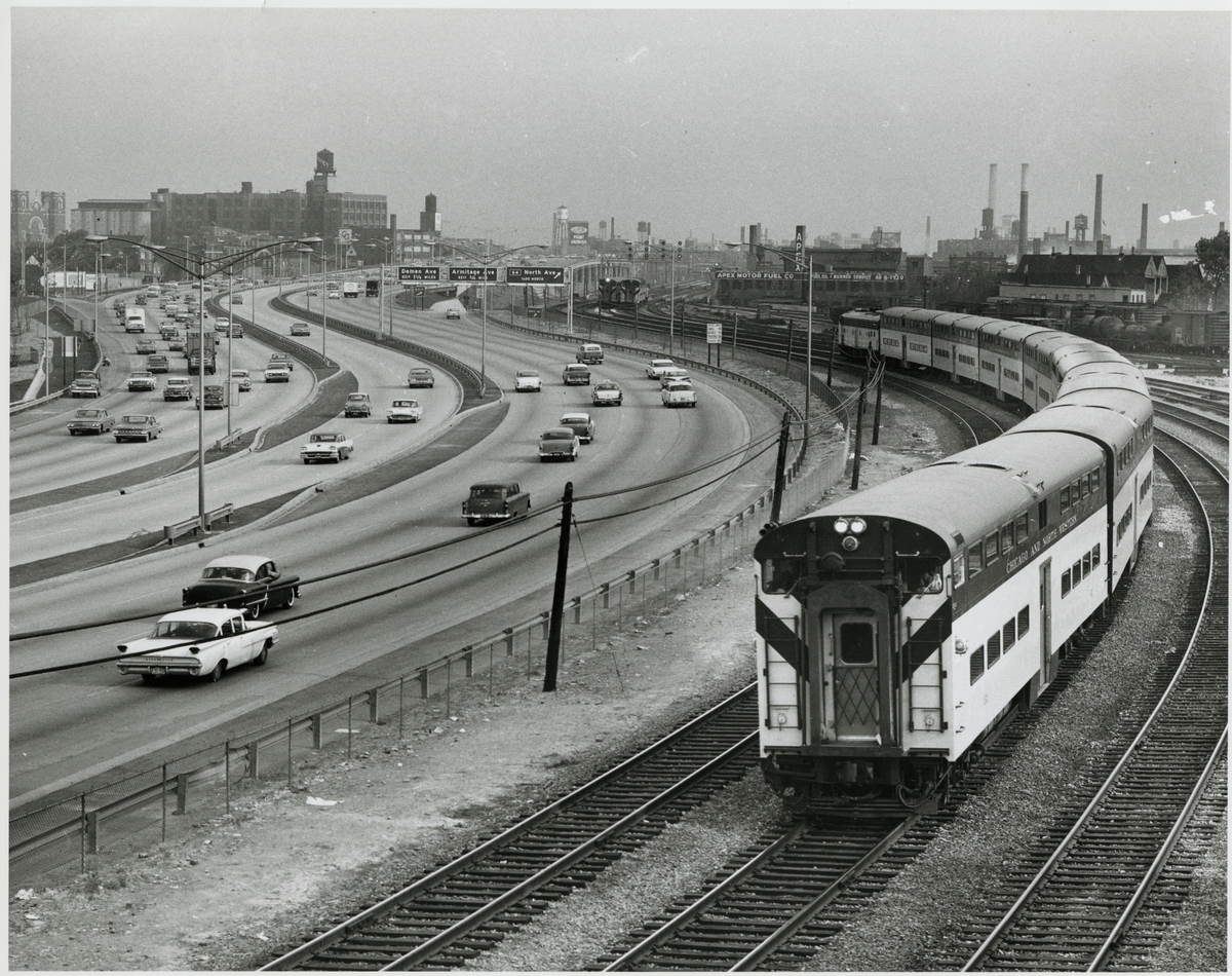 Chicago and North Western Railway, CNW persontåg bredvid en större motorväg.