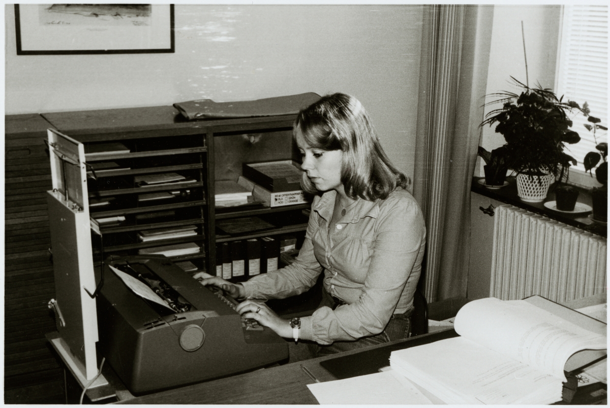 Marie Larsson vid en skrivmaskin på ett kontor.