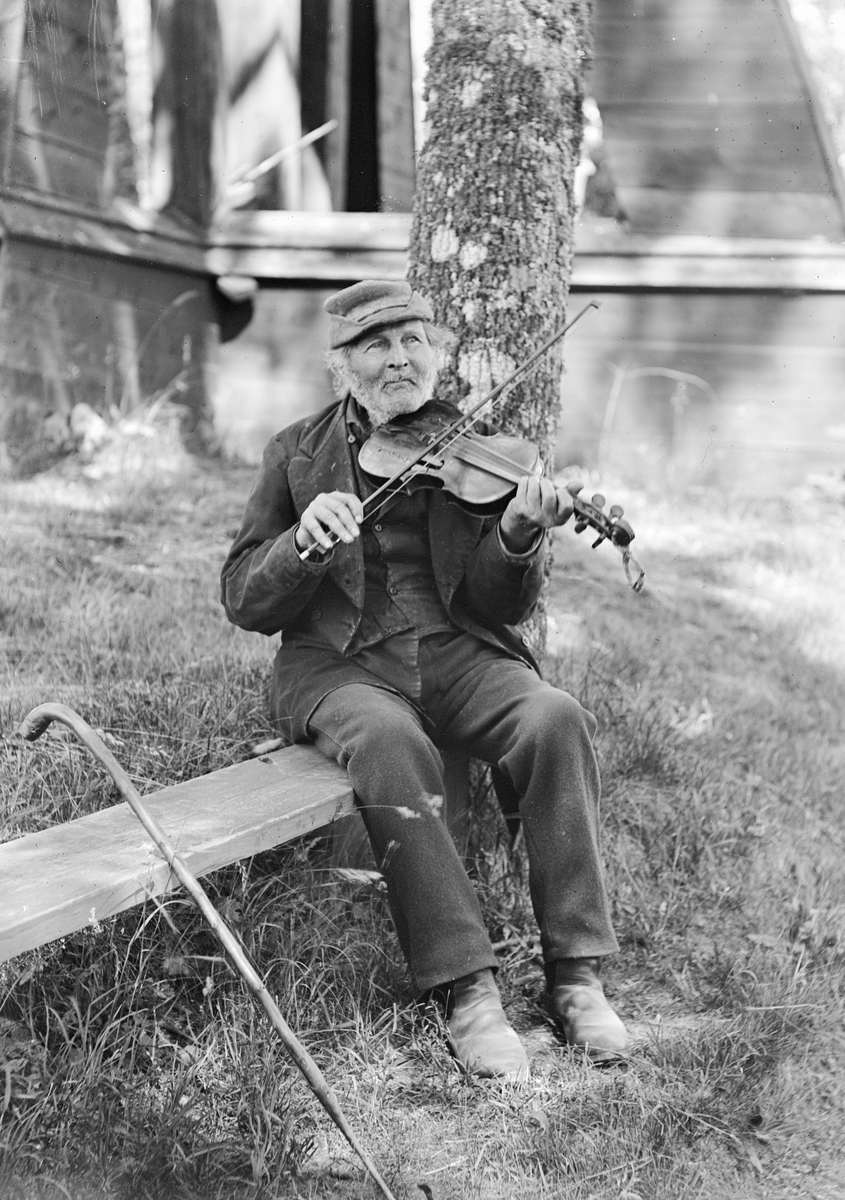 Porträtt av spelmannen Pelle Fors 1904. Hans egentliga namn var Petter Magnus Johansson Fors och var till yrket skomakare. I sin tid dock allmänt känd i de sydöstra länsdelarna för sitt fiolspel, inte sällan i så kallad näckstämning; A-E-a-ciss.
