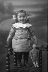 Portrett av ei lita jente med dukke.