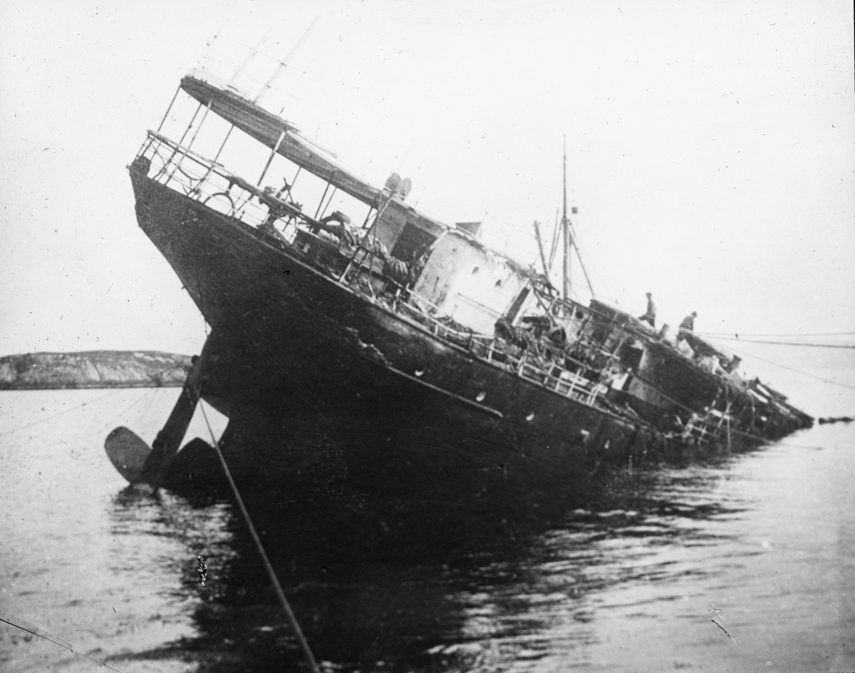 Akterenden på en fjordabåt, resten av fartøyet ligger under vann.