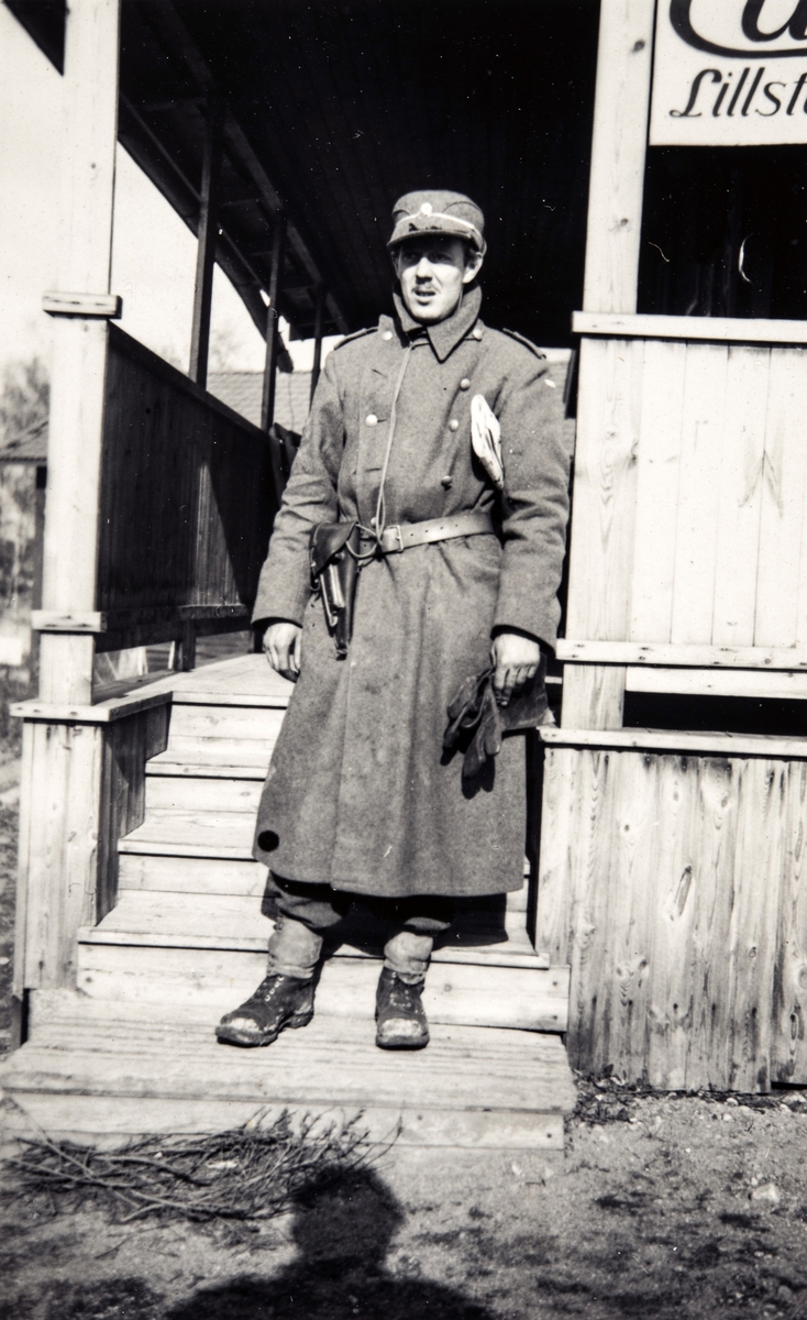 Portrettfotografi av en mann i uniform fremfor en bygning i Manøver, Helsingland under 2. verdenskrig.