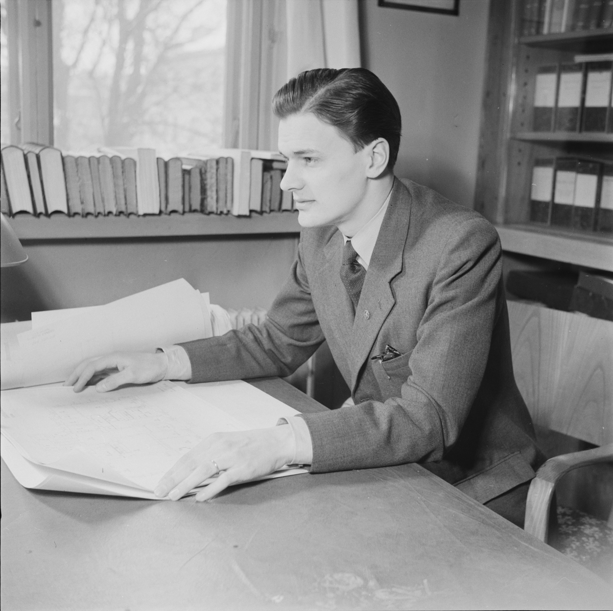 En man sittandes med ritningar, Östgöta nation inför restaurering, Uppsala 1946