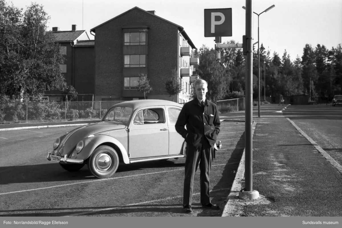 En man (Bexell) står invid en Volkswagen Bubbla på parkeringen utmed Lekängsvägen i Sallyhill.