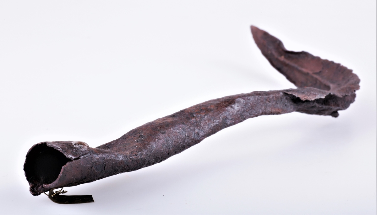 En bøyd spydspiss av jern med opphøyd rygg langs midten på bladet, på begge sider. Funnet i Vang i Valdres.