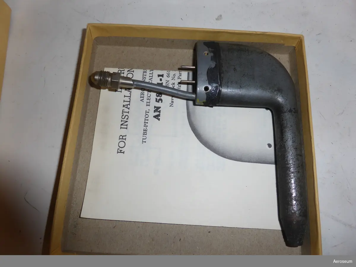 Ett Pitotrör i metall, placerat i en pappkartong. Gjord av AERO instrument Co., Inc. i USA.

På pappkartongen står det: "NSN 6610-00-515-5768 One Each TUBE-PITOT, ELECTRICALLY HEATED "L" SHAPED, INVERTED AN 5811-1 (24 Volt) INSPECTED AUG 1983 (Date) Mfg's Part No. P. H. 504 AERO INSTRUMENT COMPANY, INC. 14901 EMERY AVENUE CLEVELAND, OHIO 44135". I lådan finns pitotröret tillsammans med en liten manual där det bland annat står: "INSTRUCTIONS FOR INSTALLATION ANS MAINTENACE".