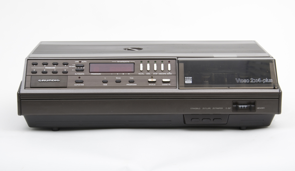 Videospiller, Grundigs analoge hjemmevideospiller "Video 2X4-plus" i formatet V2000 ble lansert i 1981, som en utbedret versjon av den opprinnelige 2X4 som kom i 1980, med tilleggsfunksjonen rask spoling, stillbilder og slowmotion. 
Grundigs (og Philips) V2000 (videoformat)system ble utkonkurrert av VHS- og Betamax-systemet, men er av mange oppfattet som et bedre filmvisningsprodukt enn disse. Kan ha blitt produsert fram til 1988.
Kassetene kunne avspilles på begge sider.
Kassethuset ligger på høyre side og lukkes med et pleksiglasslokk og under dette ligger de nye funksjonsknappene. Øvrige funksjonsknapper ligger på venstre siden for kassethuset.