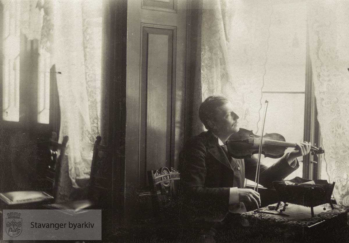 Georg T. Monsen trakterer fiolin i stua i Lilledal