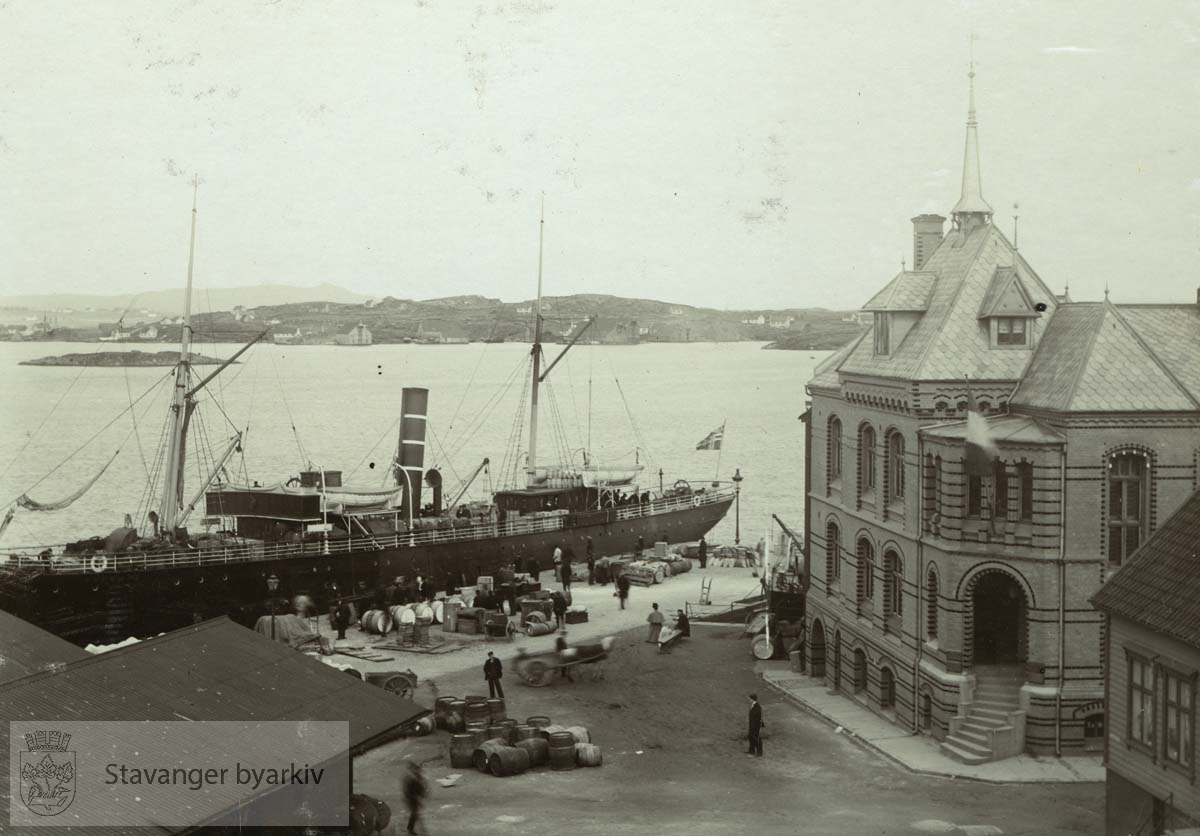 Skansekaien ble anlagt 1873-1876 og utvidet i 1892-1893. Murbygningen til høyre er Skansegaten 13, C. Middelthons dampskipsekspedisjon. Murbygningen er fra 1897.