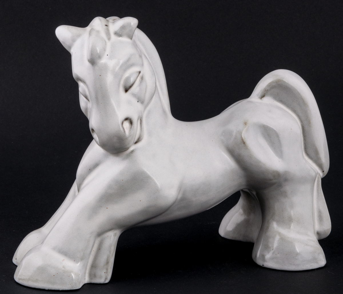 Häst, figurin i stengods, med glasyr 2560 gråvit matt tennglasyr för stengods. Formgiven av skulptör Maggie Wibom 1933.