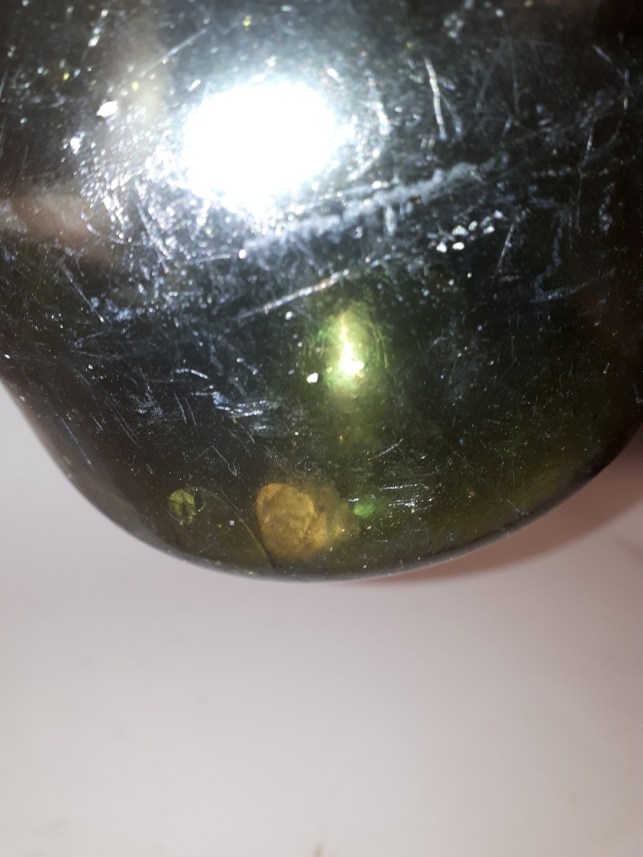 Vinbutelj i grönt glas med rund buk. Ararat. Pålagd halsring under mynningen.
Del av kork kvar i flaskan.