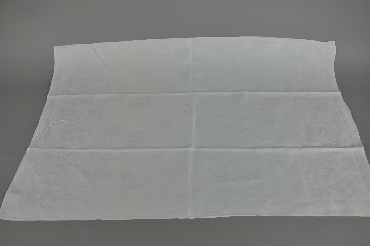 Hvitt håndkle av lin, rektangulær form.