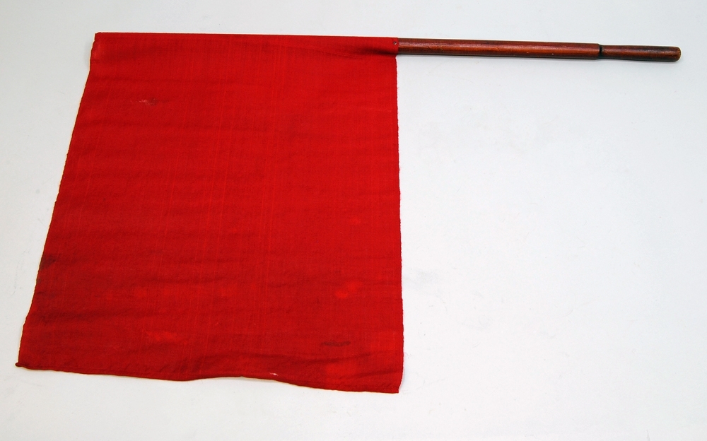 Signalflagga med röd tygflagga och trähandtag.