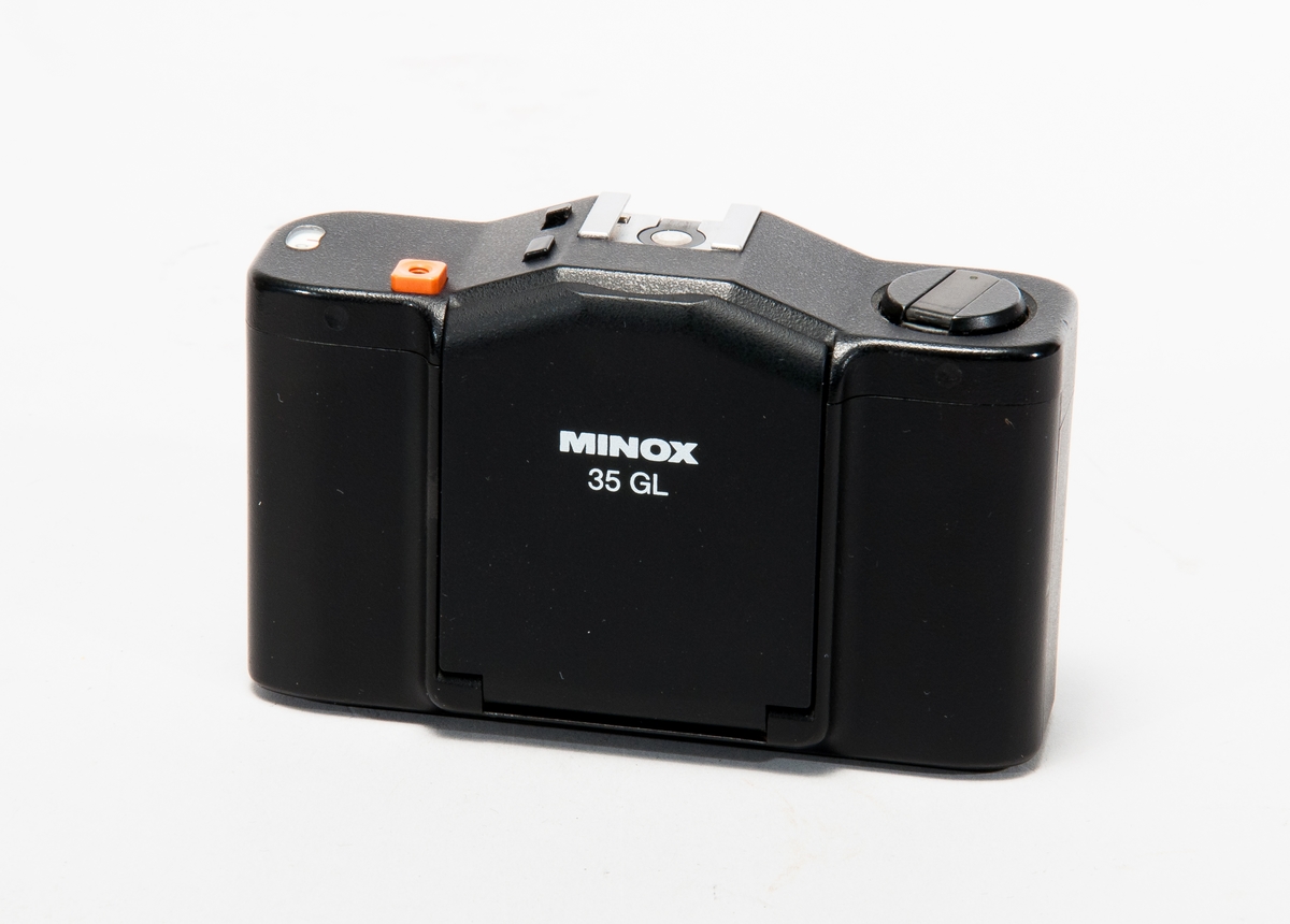 Småbildskamera Minox 35 GL i plastetui, med handlovsremförsedd läderväska.
Objektiv: Color-Minotar 1:2,8 f=35mm.