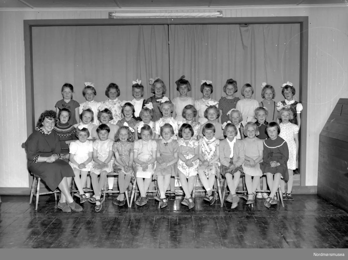 Foto fra 1. klasse ved Gomalandet skole, på Gomalandet i Kristiansund. Datering er trolig 1956. Fotograf er Nils Williams. Fra Nordmøre museums fotosamlinger.