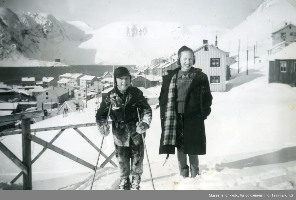 Honningsvåg. John og Berit Grøtta. I bakgrunnen deler av Gjenreisningsbebyggelsen. Ca. 1955.
