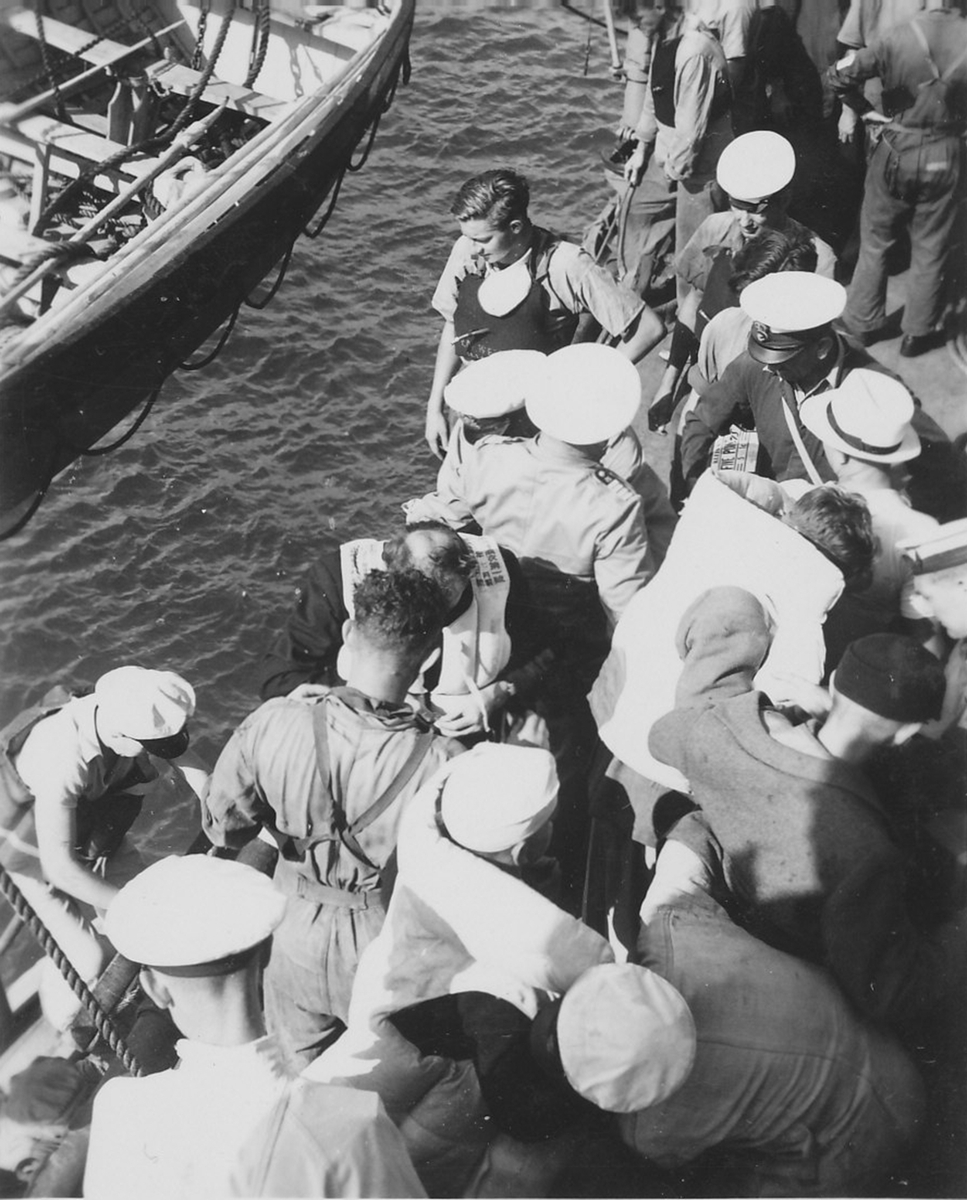 Overlevende fra 'Ramses' langs skipsiden ved HMAS 'Adelaide'.