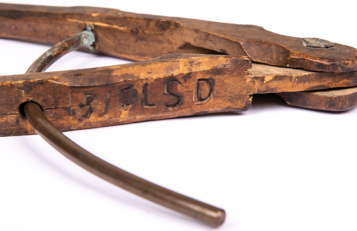 Passare av trä försedd med metallstift längst ned i ena benet. Ristade märkningar: LSD 1815 HH.