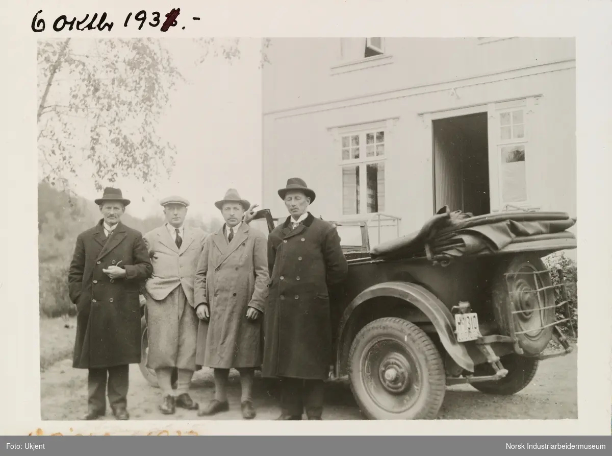 Fire menn men hatter og ytterjakker står foran bil med åpent tak. Bilen er en Amerikansk Oakland fra ca 1922. I 1930 var bilen reg. på Kjøpmann H. O. Hauganu, Tinn, Austbygd i følge Bilboken av 1930.