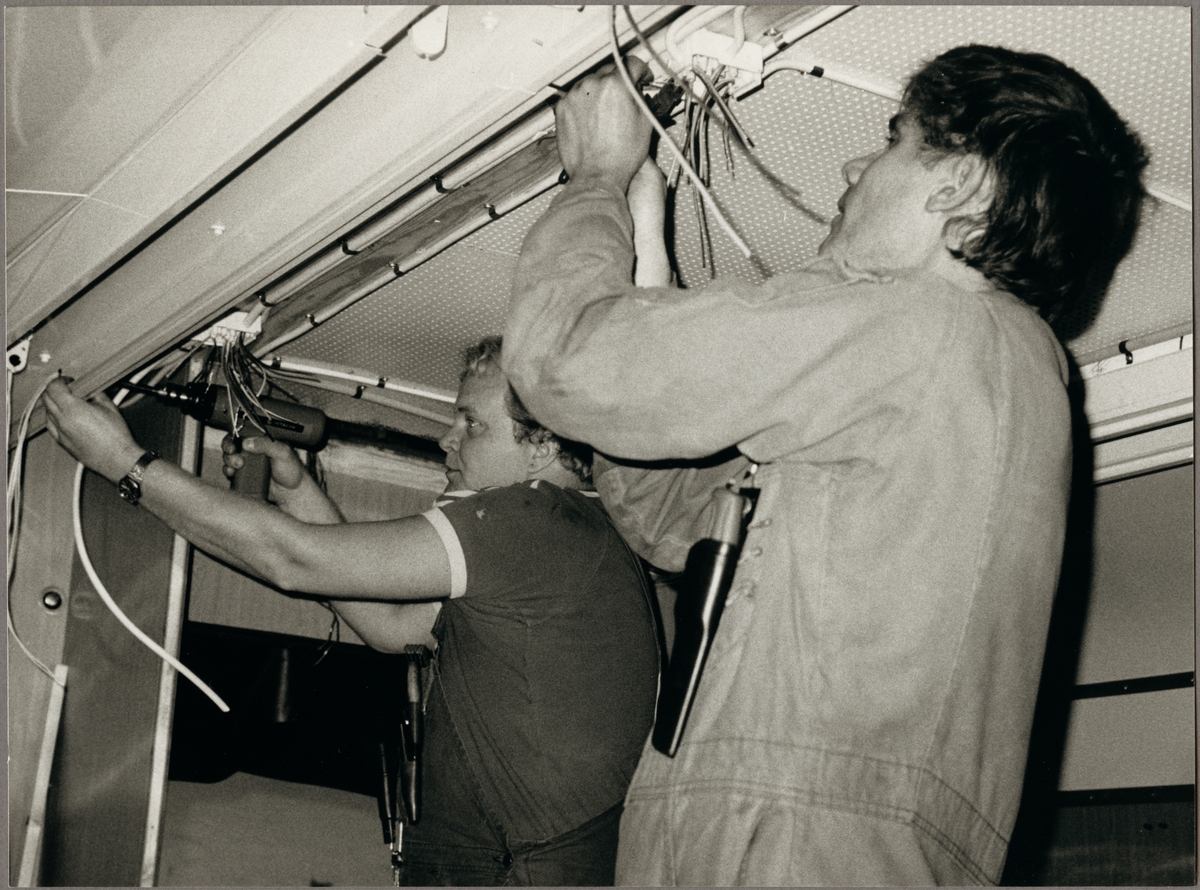 Montering av nya lysrörsramper i taket på en X20 utförs av Kjell Andersson och Arne Högberg.