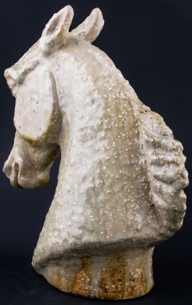 Modellerad figurin i stengods, föreställande ett hästhuvud. Utförd som ateljéproduktion av Lillemor Mannerheim 1956 eller 1957 som förlaga till den formgjutna figurinen Hästhuvud som producerades av Gefle 1957-1964.