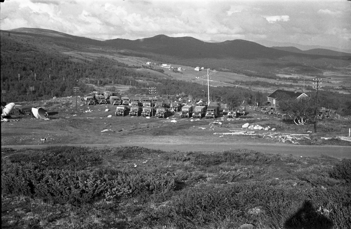 To avfotograferte bilder av en rekke militære kjøretøy parkert i terrenget ved sida av en veg. Stedet er ikke identifisert.