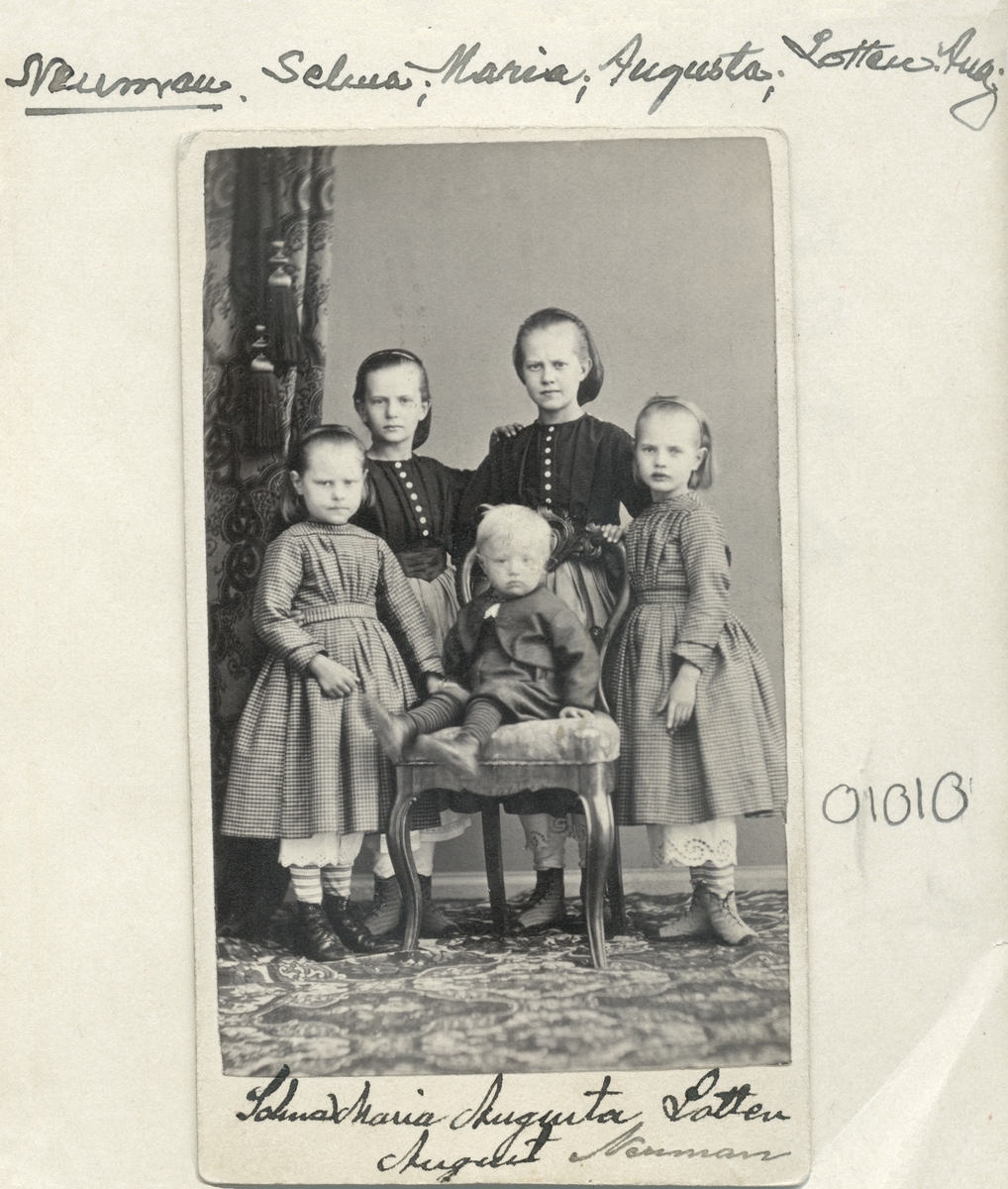 Porträtt av barnen till målarmästaren i Linköping, August Neuman och hustrun Karolina Sofia Wallin. Från vänster ses Selma, Maria, Augusta och Lotten. På stolen sitter sonen August.