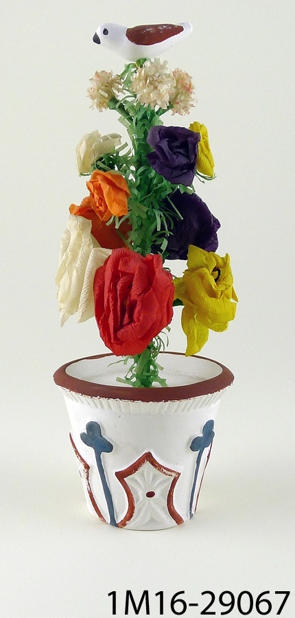 Blomma av papper i kruka av gips, i toppen en fågel, gjord av en sotare i Kylingared.