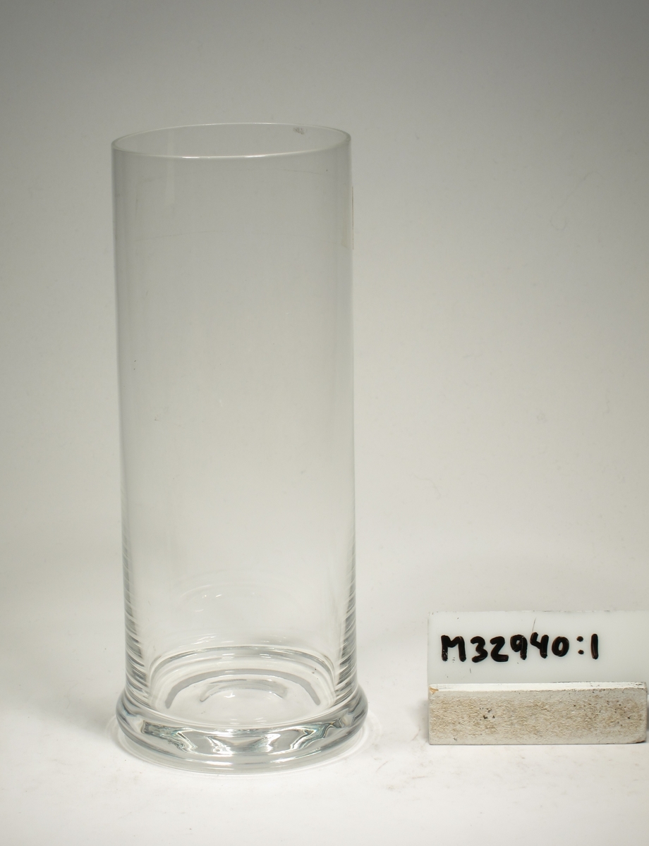 Cylindriskt glas med låg klack.
Oläslig signering.