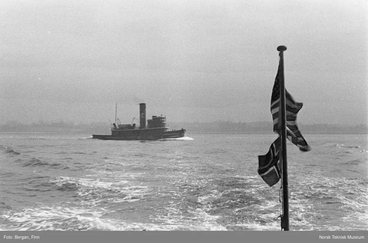 Flagg amerikansk og norsk mot skjølvannet av et skip