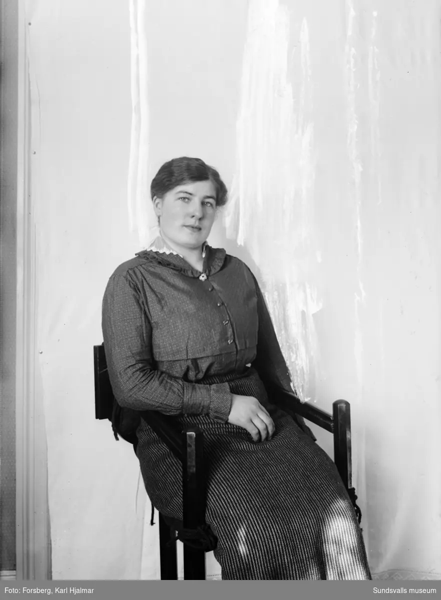 Porträtt på Anna Karlsson. Ett lakan med spets har använts som fond. Klumpig retusch gjord direkt på negativet.