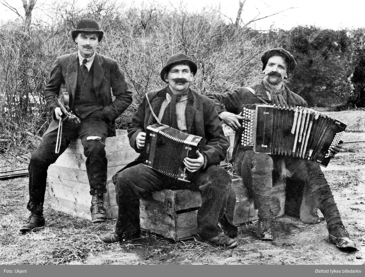 Tre musikanter med fiolin og torader i ca. 1920- 1929. Ukjente personer og ukjent sted, muligens et sted i Østfold?