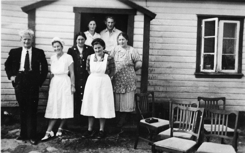Astri Ødegård (1902 - 1986) med døtre og hjelpesmenn under førebuinga til bryllup for dottera Sigvor Ødegård (1930 - ). Spisestuestolar til høgre.