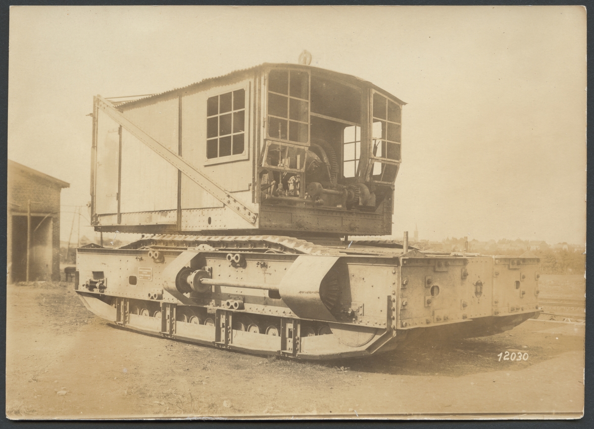 Bilden visar ett större bandfordon som verkar vara en demonterad grävmaskin som enligt påskriften har används för ammunitionstransport under första världskriget.