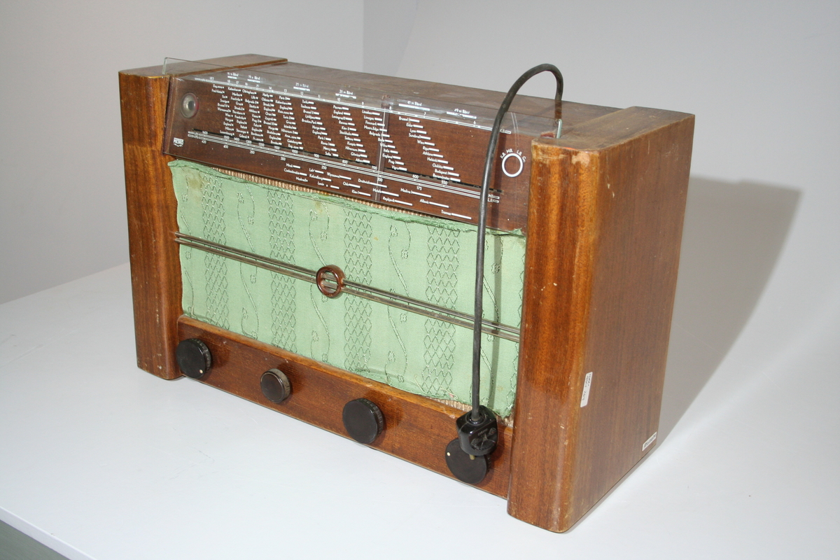 En rektangulær radio med inngang  for grammofon, 220-240V, 145-160V, 110-130V og  utgang for eksterne høytallere, antenne, jord. Det er innebygd høytaler. Det er satt inn et grønnt stoff over det orginale stoffet over høytaleren