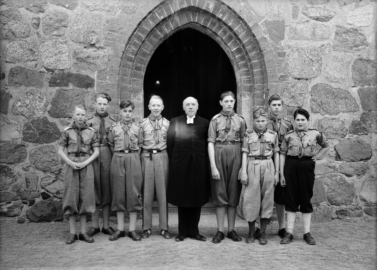 Präst med pojkscouter utanför Gamla Uppsala kyrka, 1950