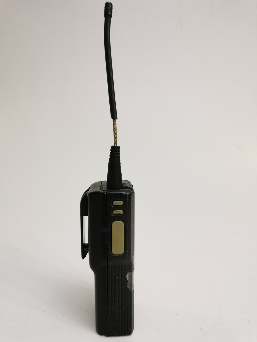 Kommunikasjonsradio  med antenne , to brytere på toppen,  festeanordning for oppheng i en lomme bak på radioen,  tre knapper på siden, batteri.