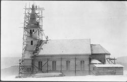 Bygging av Randsfjord kirke. Arbeidere på stillas rundt tårn