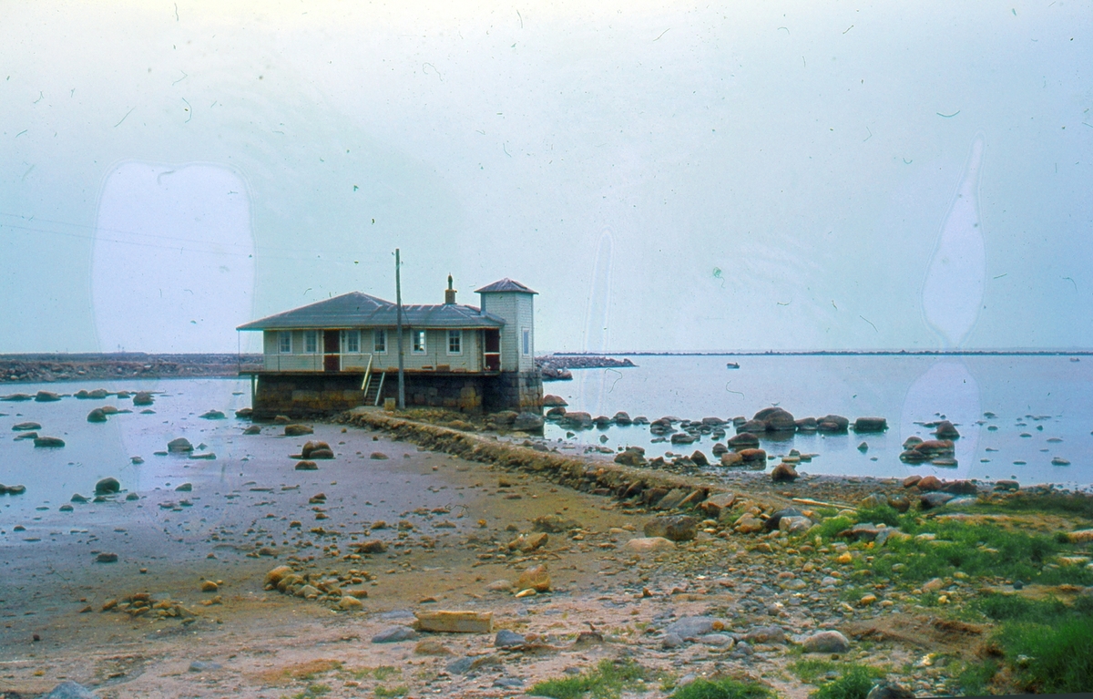 Färgretuscherat foto (FMA.04792). Första kallbadhuset på Falkenbergs strand. Anlades på 1800-talet. Sedan "Patriks badhus".