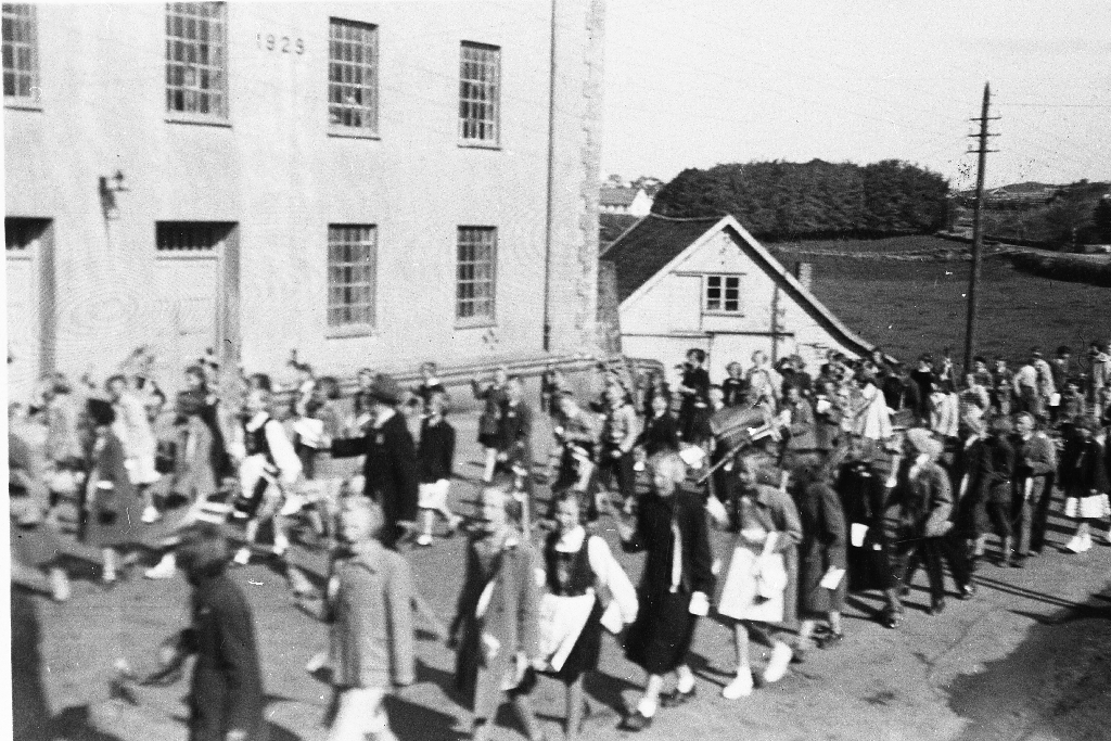 Barnetog 17. mai i slutten av 1940 åra. Bryne Mølle og det gamle slakthuset i bakgrunnen.