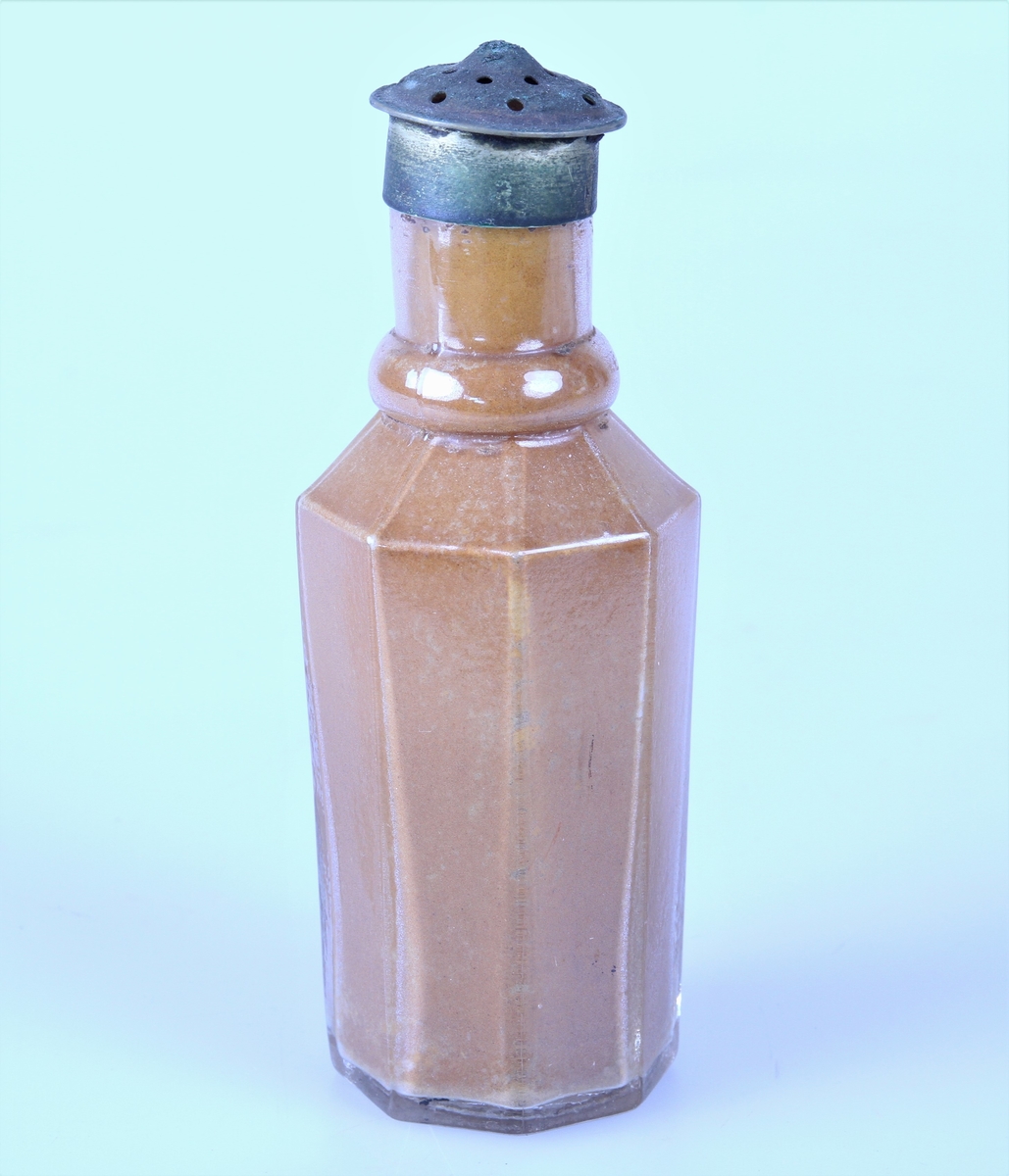 Åttekantet krydderflaske med strølokk av metall.