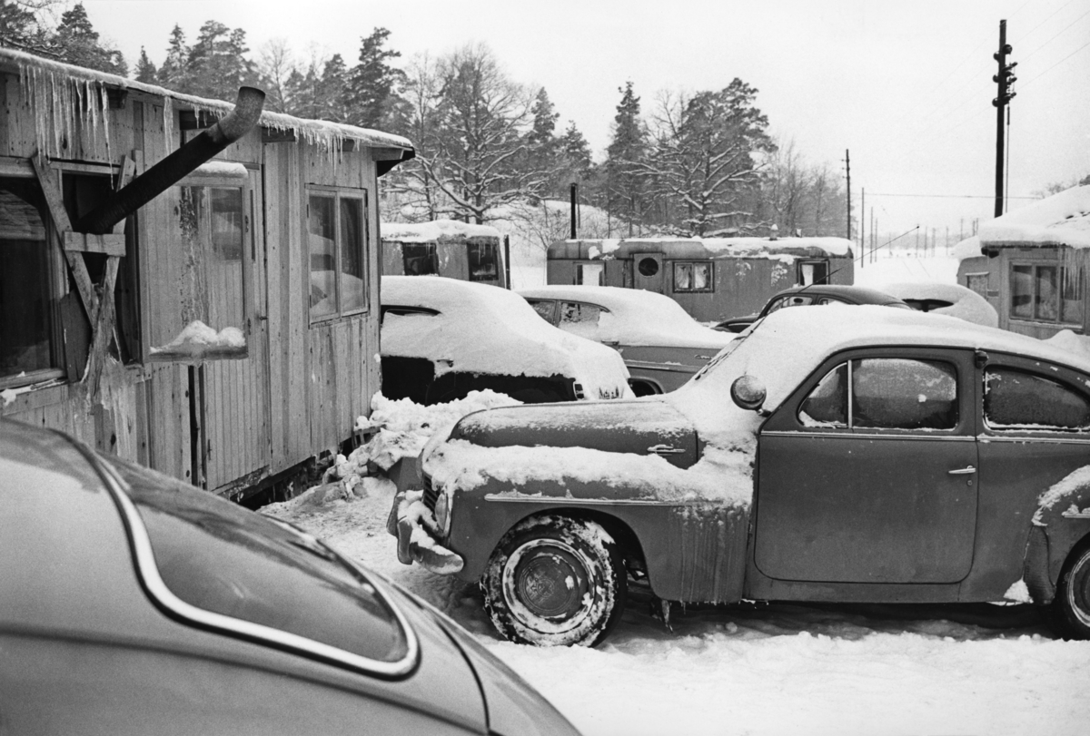 Romskt läger i Ekstubben 1963. Bostadsvagnarna är täckta i snö och från taken hänger istappar.
