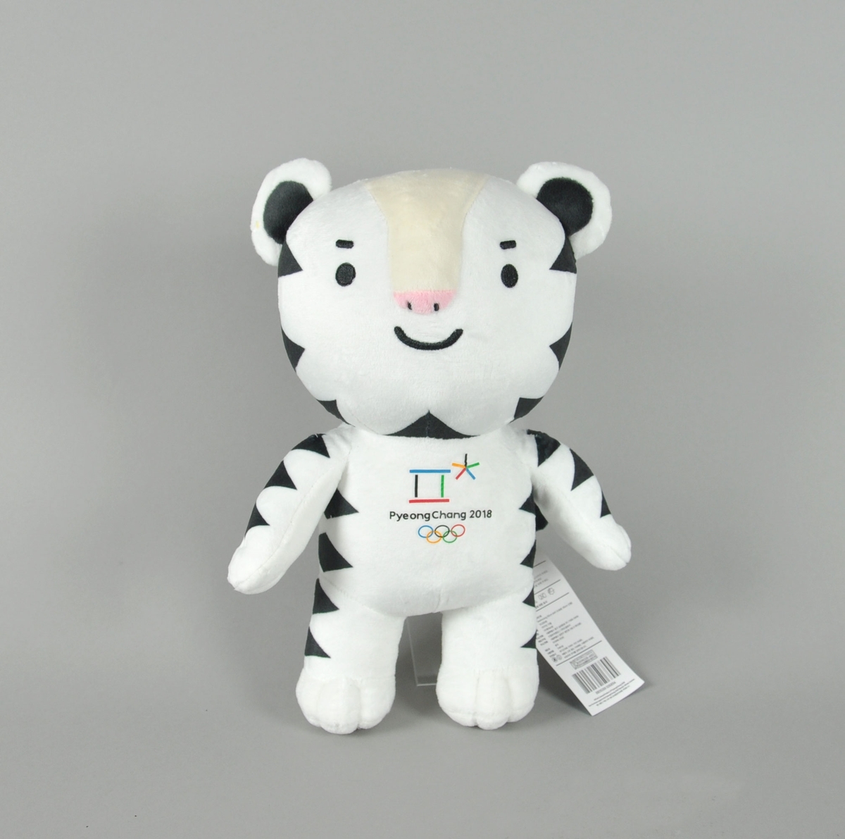 Hvit bamse / figur med svarte flekker. På brystet er logo for Vinter-OL i PyeongChang brodert over de olympiske ringer.